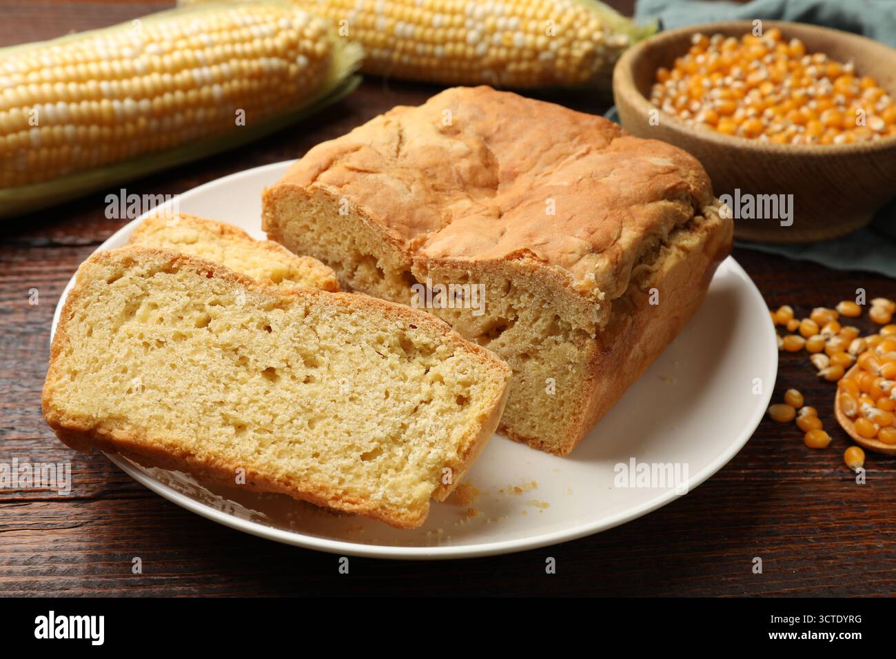 Freshly baked cornbread, cobs and seeds on wooden table, closeup Stock Photo