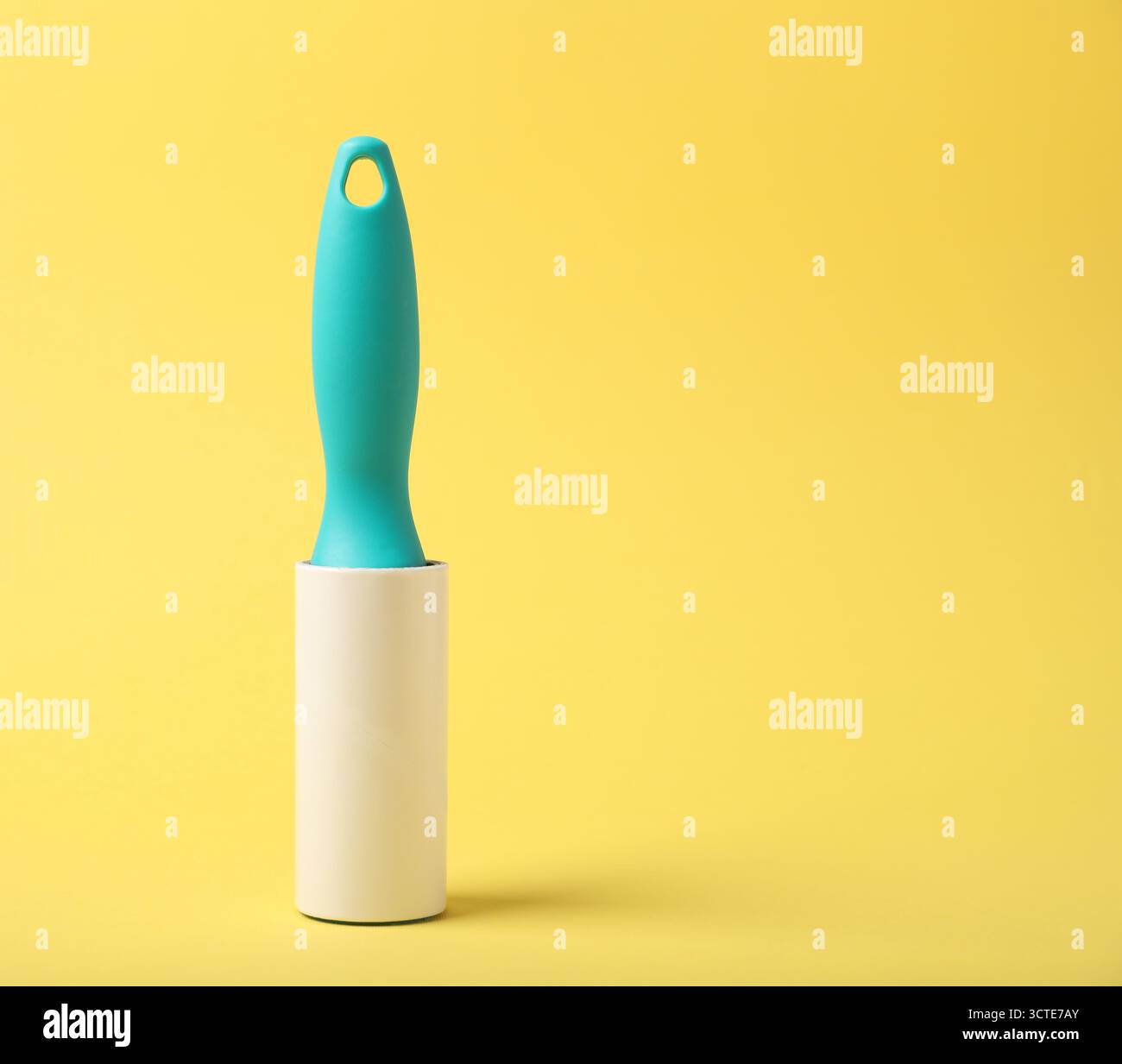 One lint roller on yellow background, space for text Stock Photo