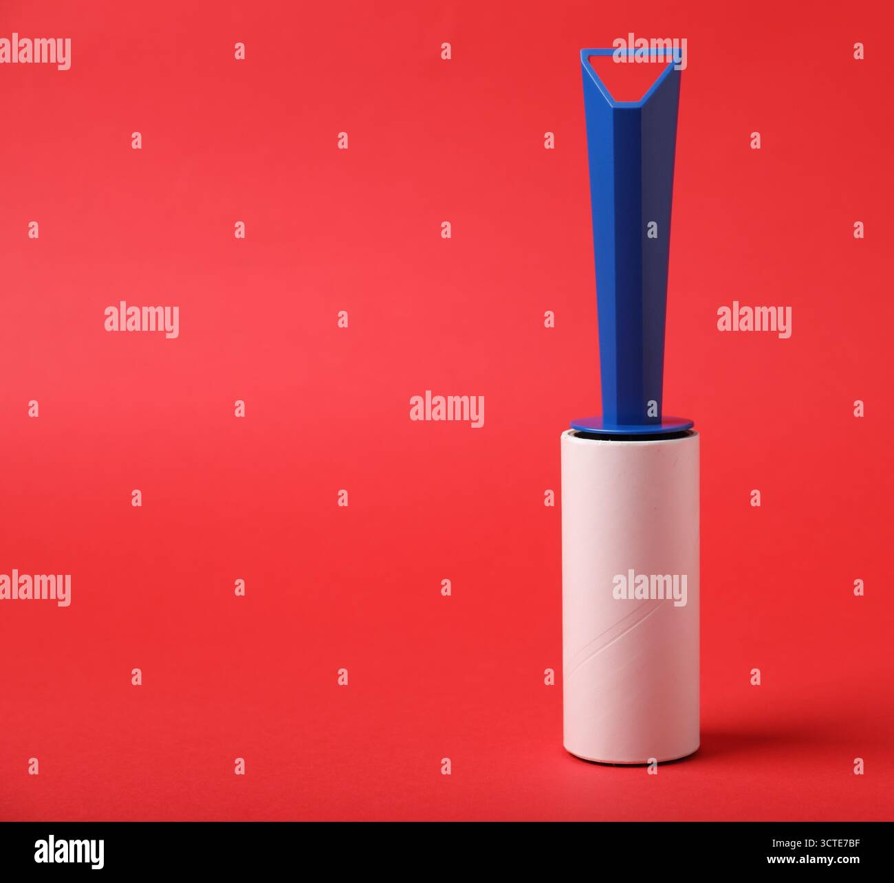 One lint roller on red background, space for text Stock Photo