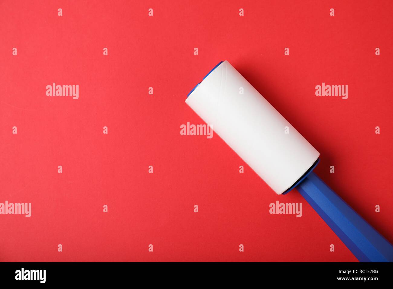 One lint roller on red background, top view. Space for text Stock Photo