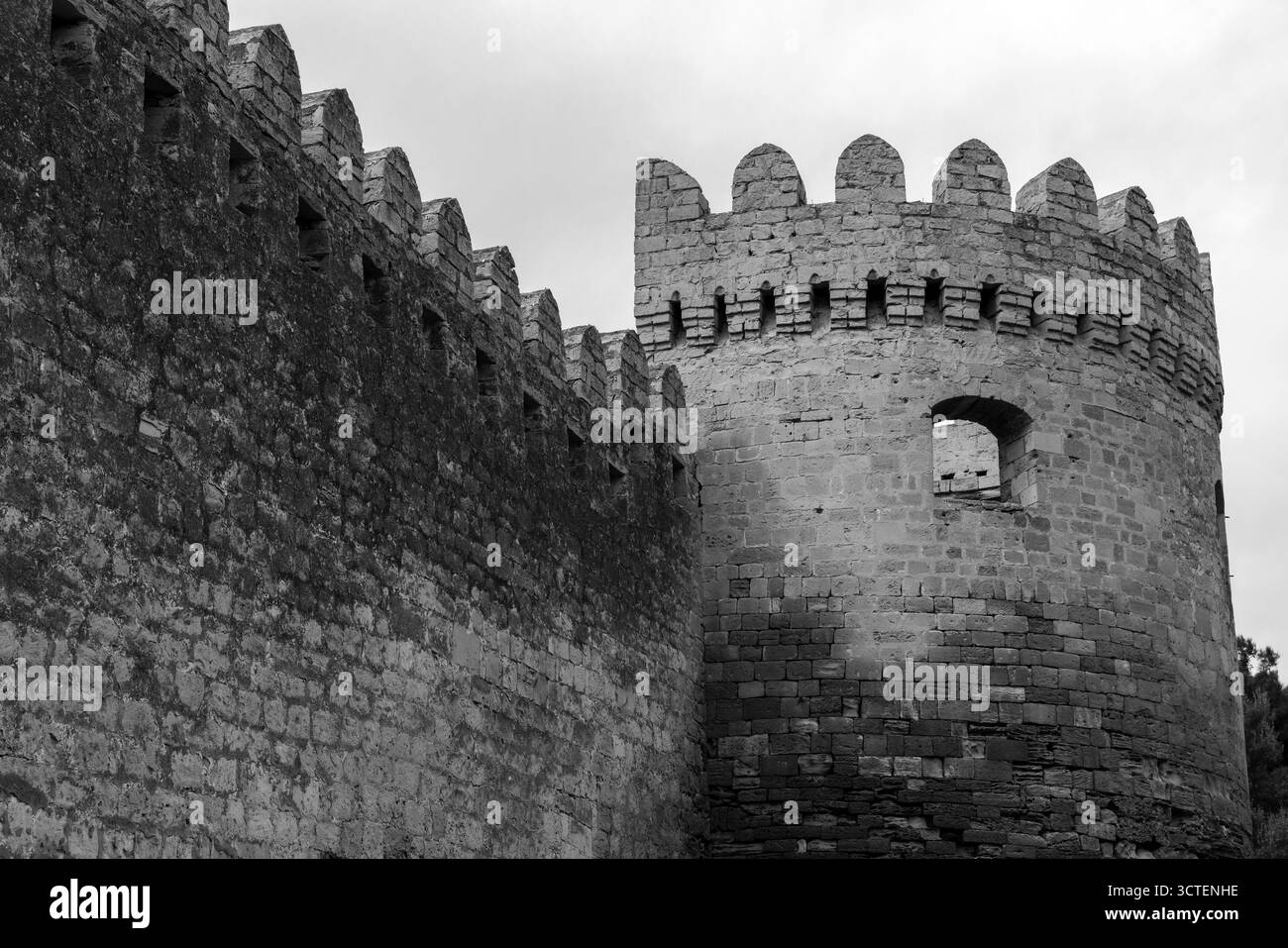 Black and white image of a medieval fortress featuring a high stone ...