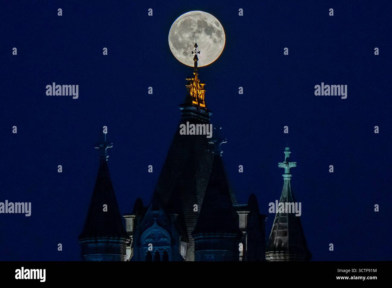 The Harvest Supermoon rises behind Tower Bridge, Monday, Oct. 6, 2025 ...