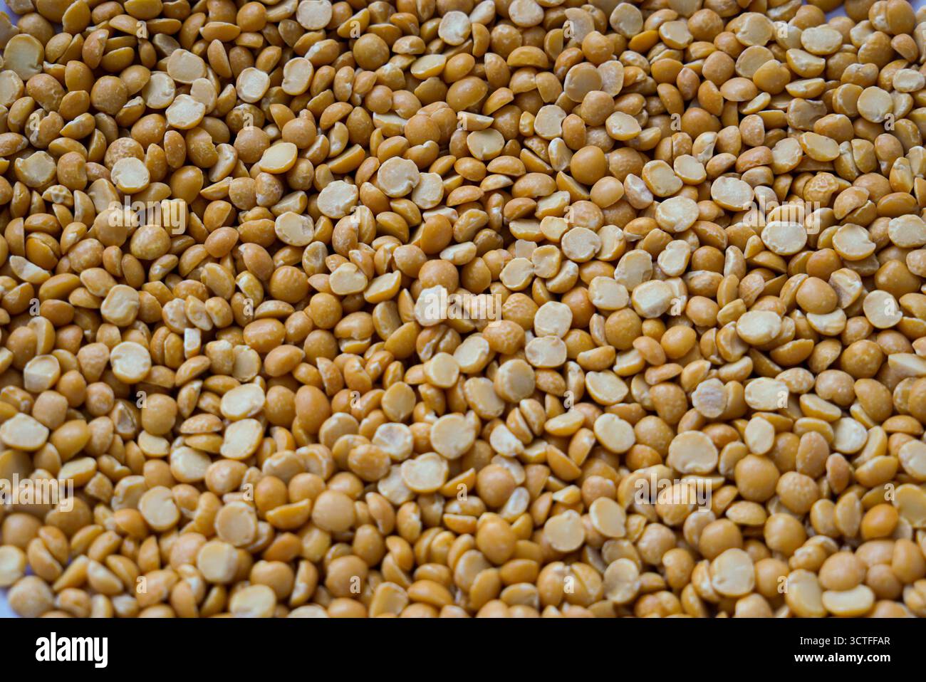 Dry split yellow peas scattered all around the perimeter of the photo Stock Photo