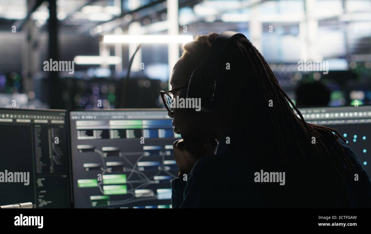Data center engineer using algorithms to analyze large datasets, putting on headphones. Server farm IT professional using artificial intelligence to recognize data patterns listening music, camera B Stock Photo