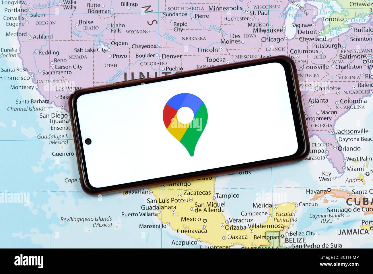 Close up to an a smart phone with the google maps logo and a white ...