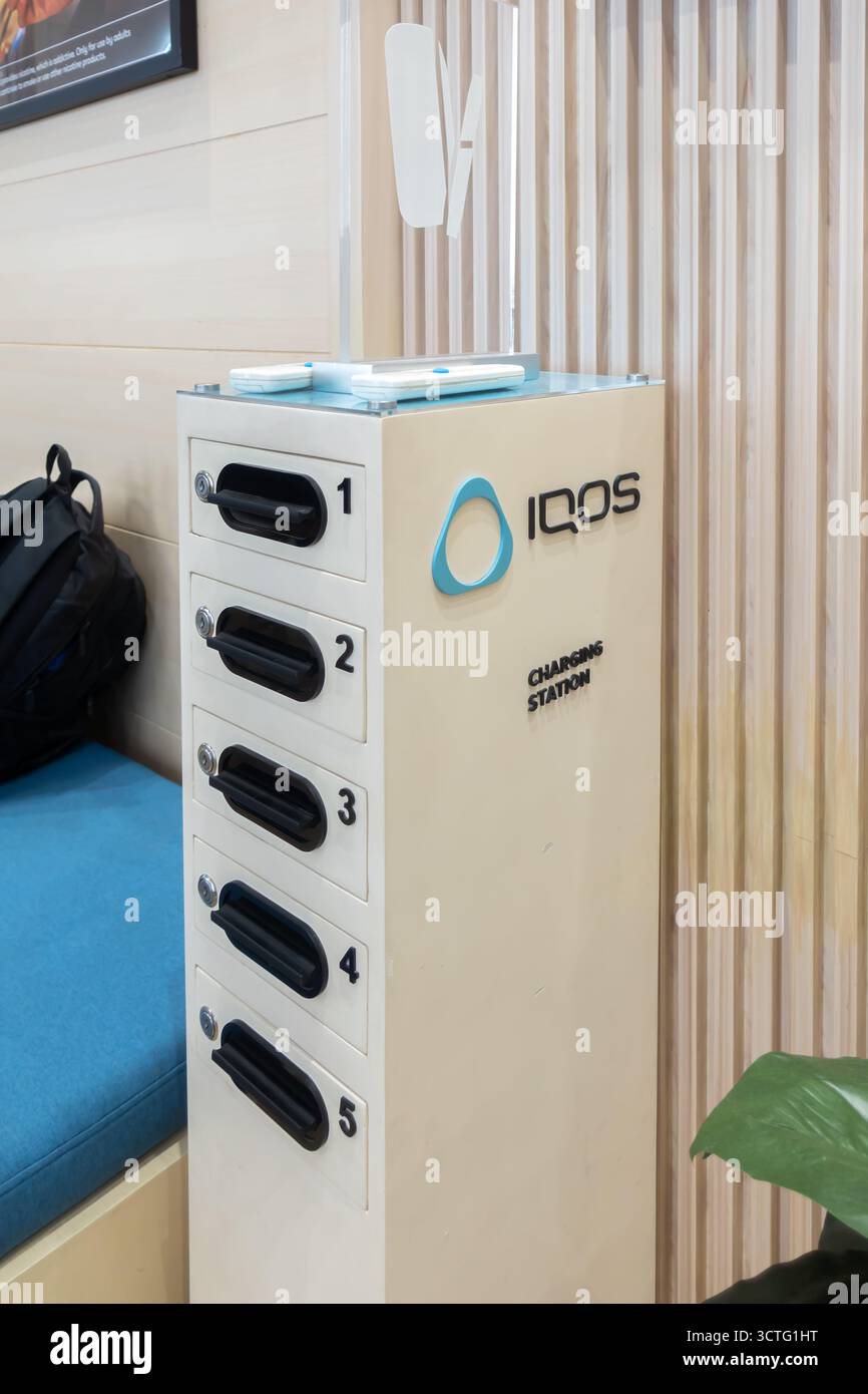 Iqos e-cigarettes sponsored charging station for smartphones, mobile devices, electronics, USB ports at Manila airport, Philippines Stock Photo