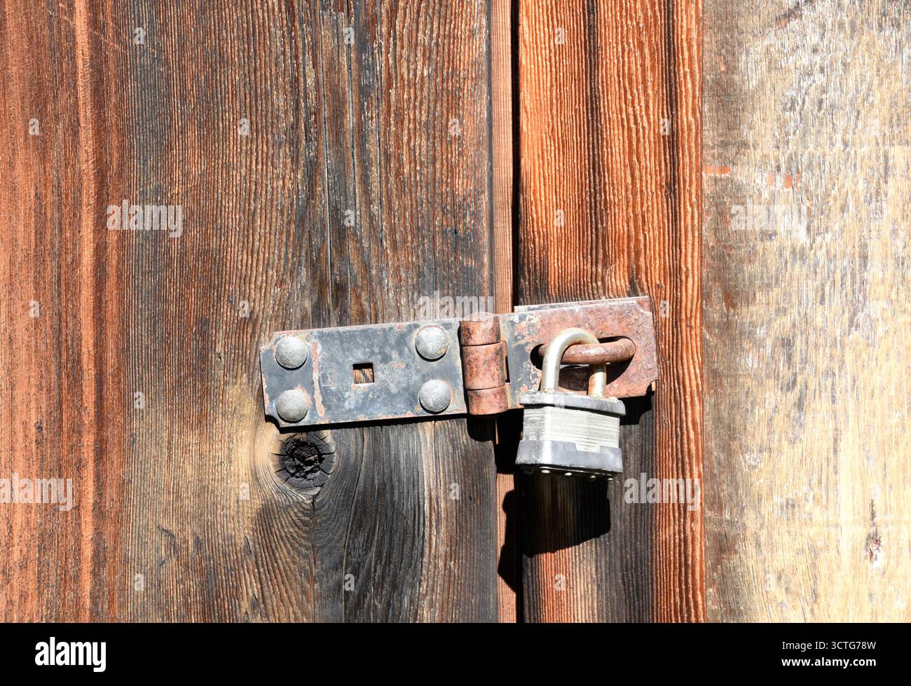 Old lock on a rustic abandoned wooden building Stock Photo