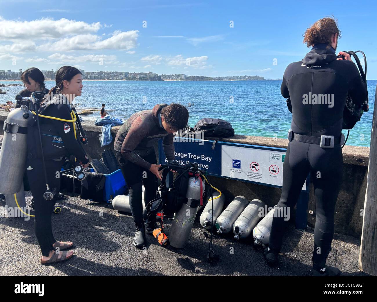Scuba divers gearing up for a dive at Cabbage Tree Bay Aquatic Reserve, Manly, Sydney, NSW, Australia. No MR or PR - Smartphone Captured Stock Image