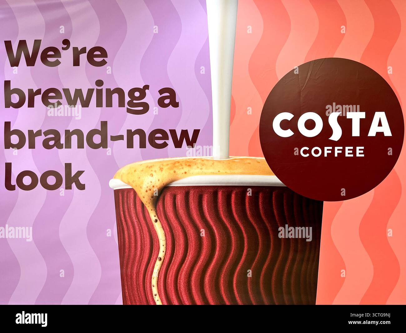Costa Coffee branded cup with pouring coffee, iconic logo and signature coffee experience, new look - Smartphone Captured Stock Image