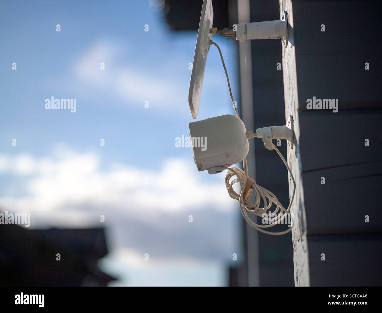 a surveillance camera powered by a solar panel and mounted on the wall Stock Photo