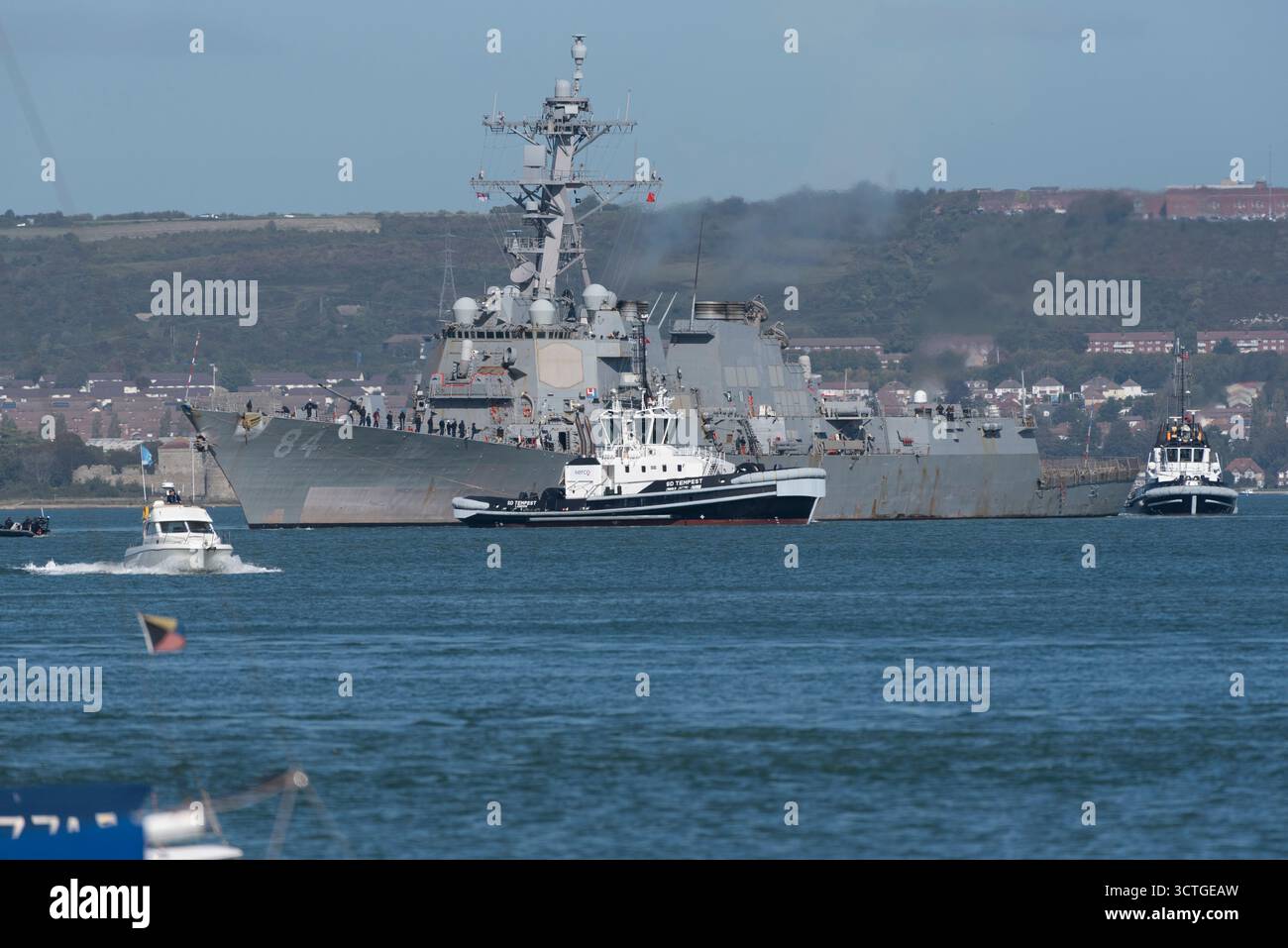 Portsmouth England UK. 06.10.2025. The USS Bulkeley with tugs in attendance leaving the naval base in the Port of  Portsmouth UK - Stock Image