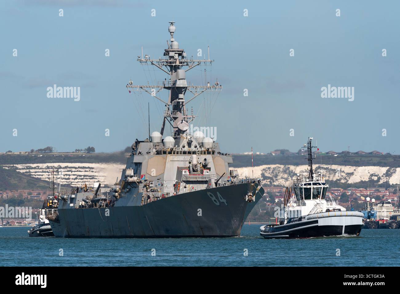 Portsmouth England UK. 06.10.2025. The UsSS Bulkeley with tugs in attendance leaving the  naval base in the Port of  Portsmouth UK Stock Photo