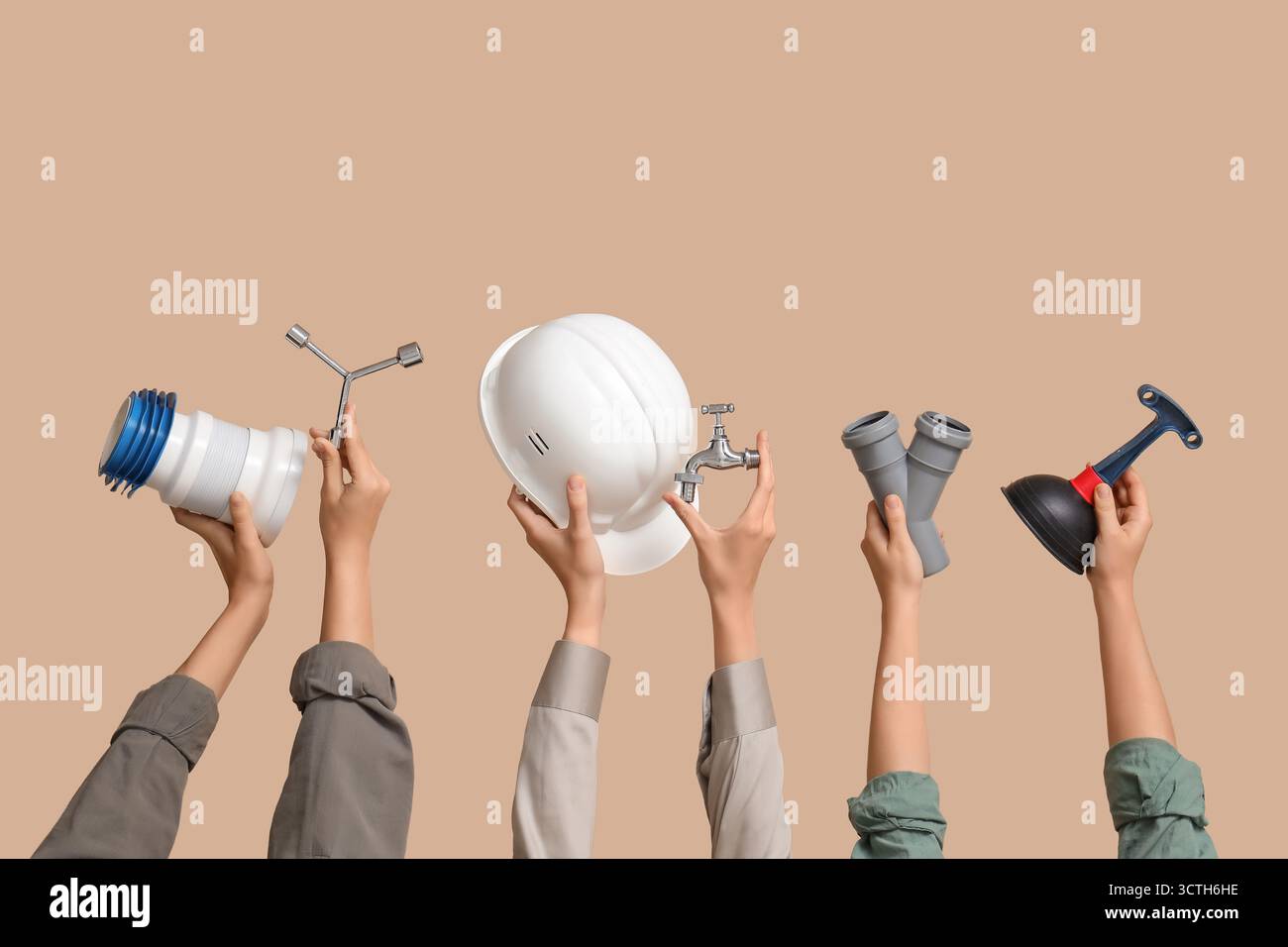 Hands with hardhat and plumber supplies on beige background Stock Photo