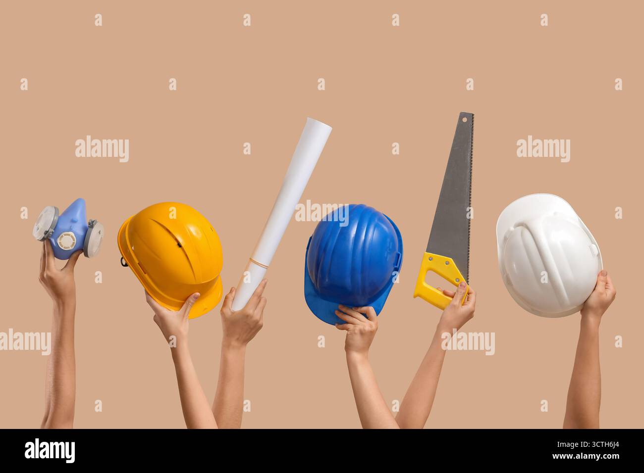 Hands with hardhats and construction tools on beige background Stock Photo