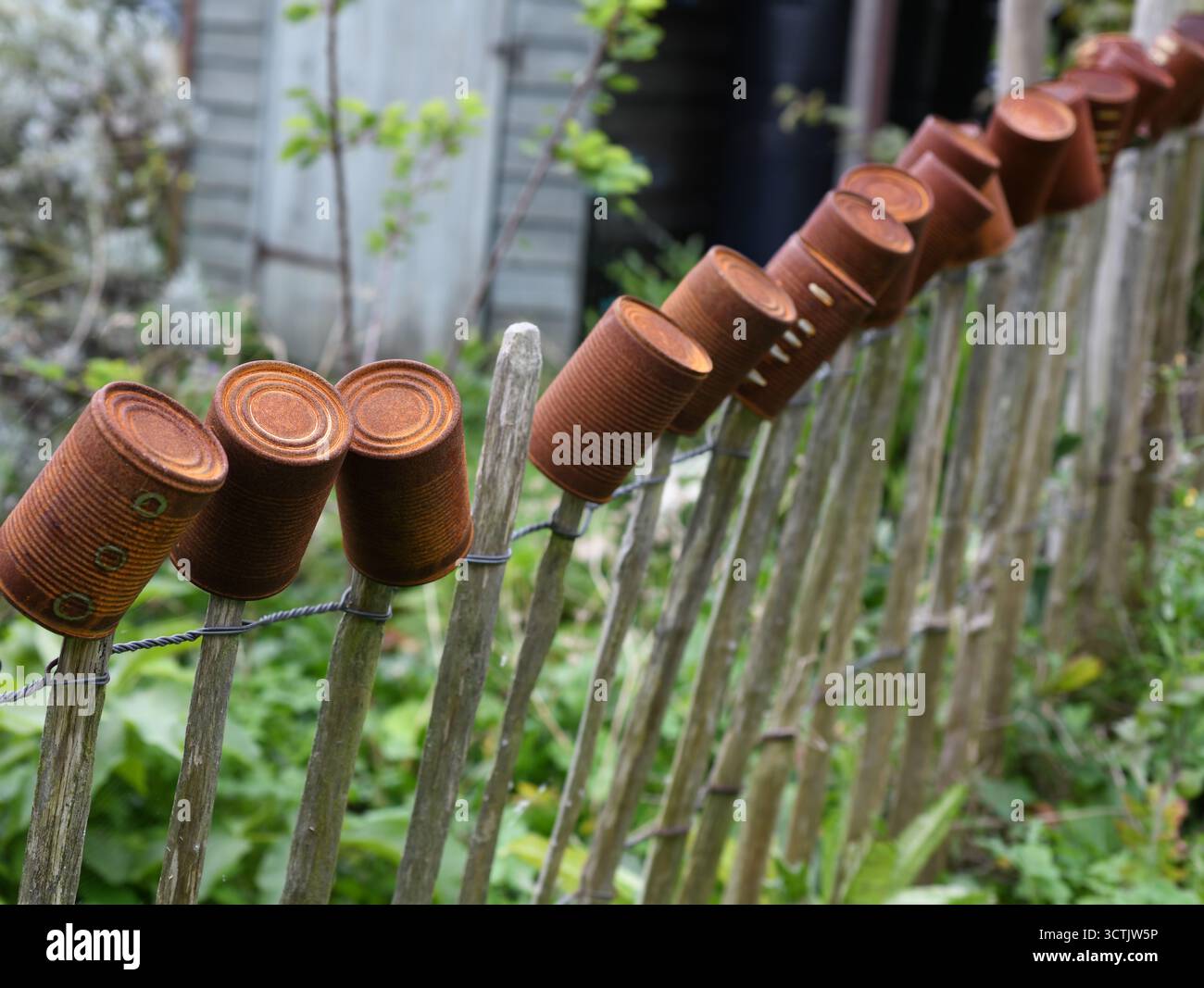 Tin cans along a picket fence Stock Photo