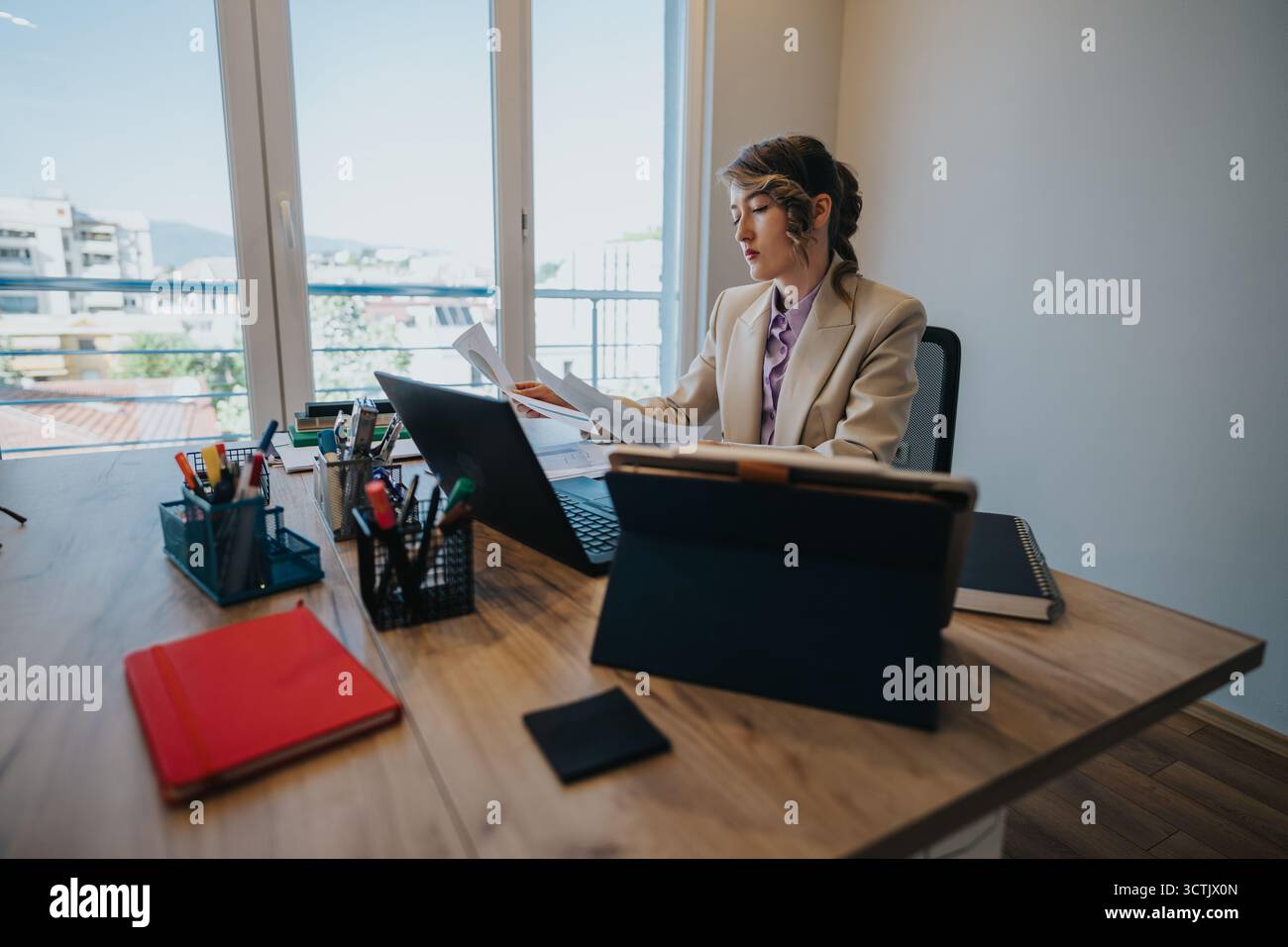 Young professional analyzing documents in an office setting during financial consultation Stock Photo