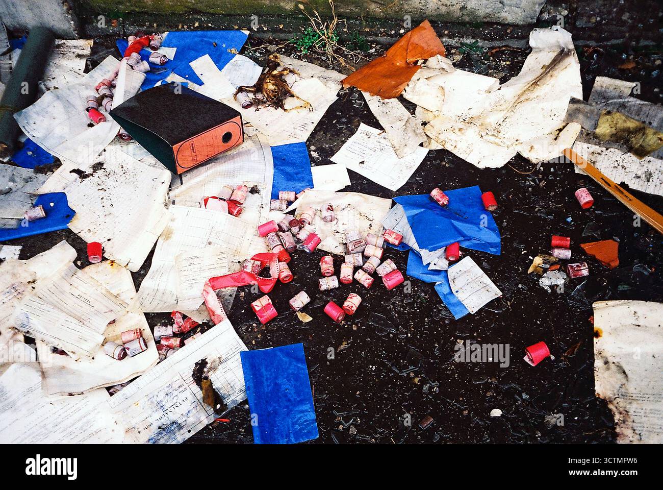 Old office materials thrown on the ground, with wet papers scattered around. Analog look. Stock Photo