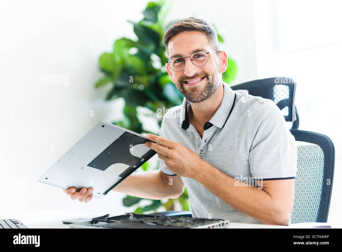 Handsome engineer repairing laptop computer. Stock Photo