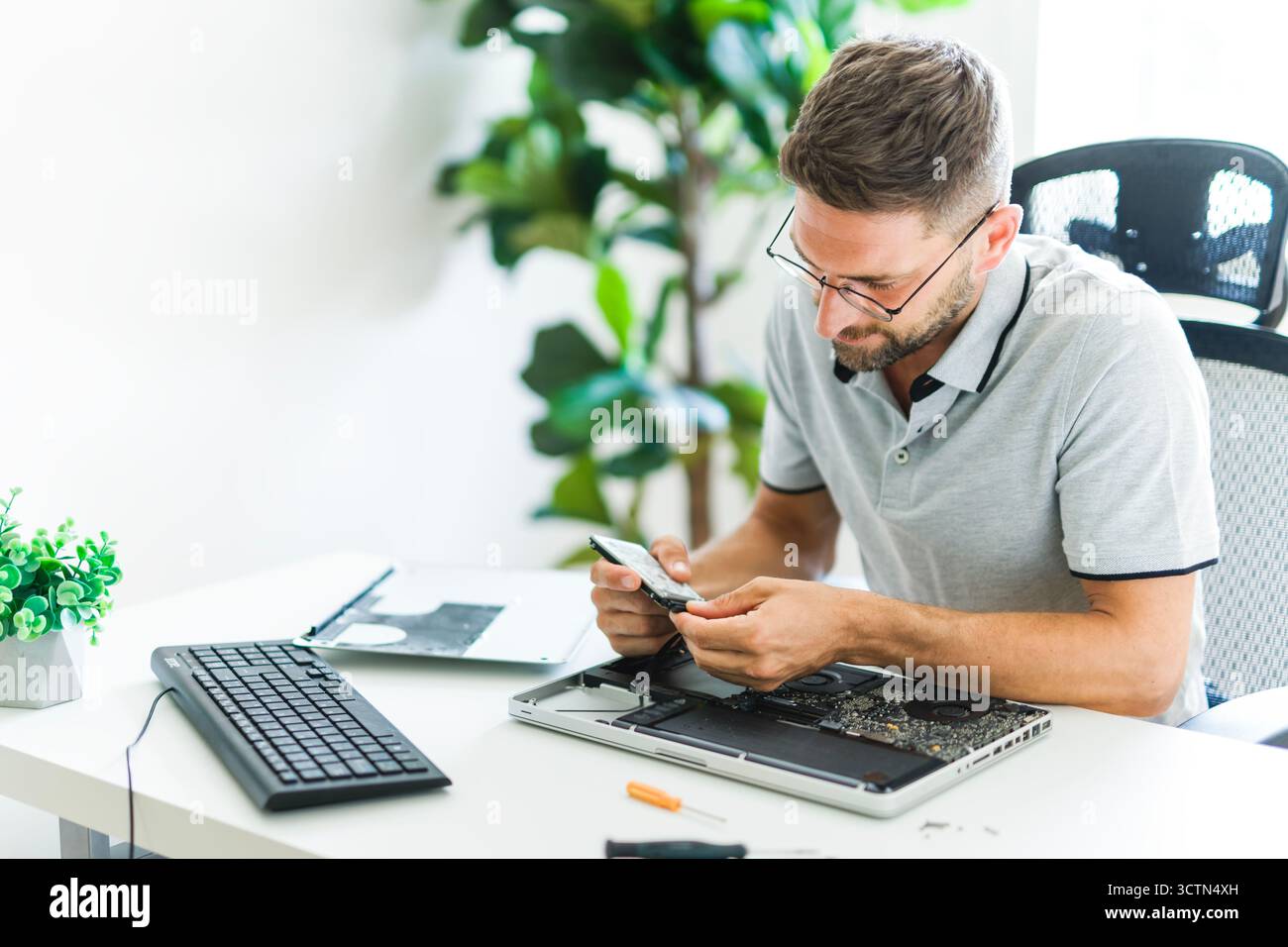 Handsome engineer repairing laptop computer. Stock Photo