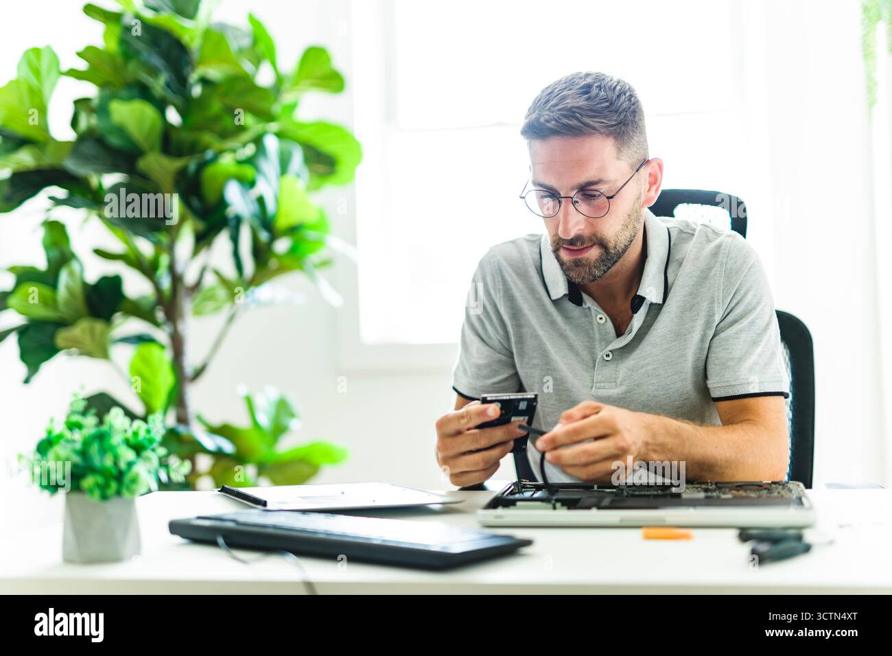 Handsome engineer repairing laptop computer. Stock Photo