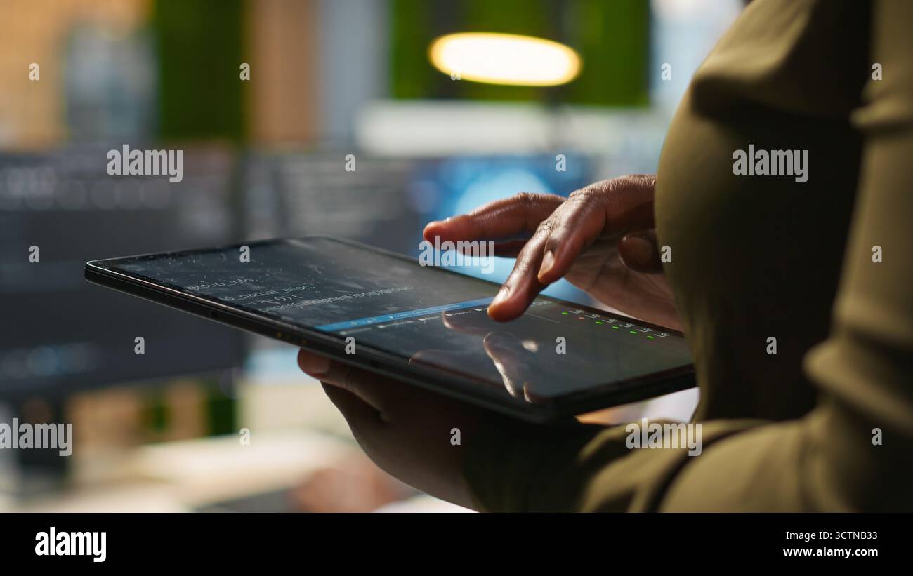 Close up of engineer using tablet to write code, developing machine learning APIs. IT professional troubleshooting software errors and faults using artificial intelligence, camera A Stock Photo