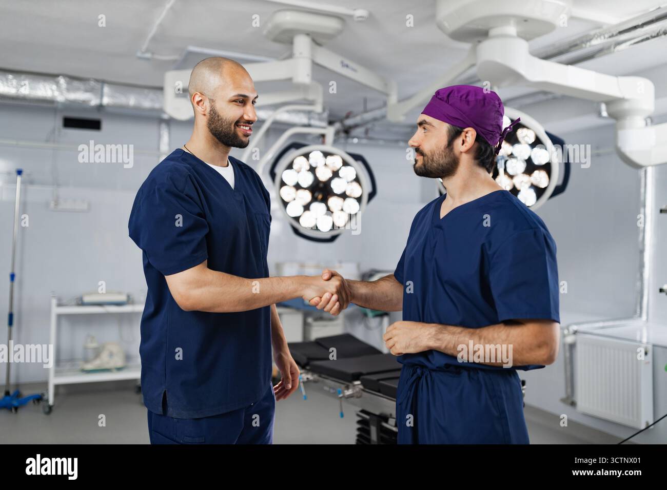 Surgeons Handshake in Operating Room Stock Photo
