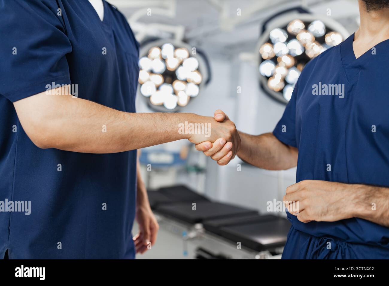 Surgeons Handshake in Operating Room Stock Photo