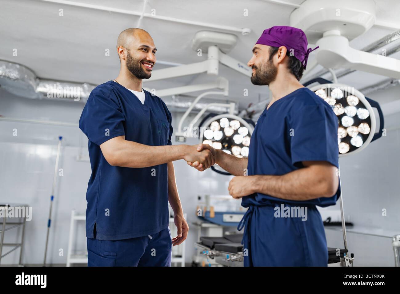 Surgeons Handshake in Operating Room Stock Photo