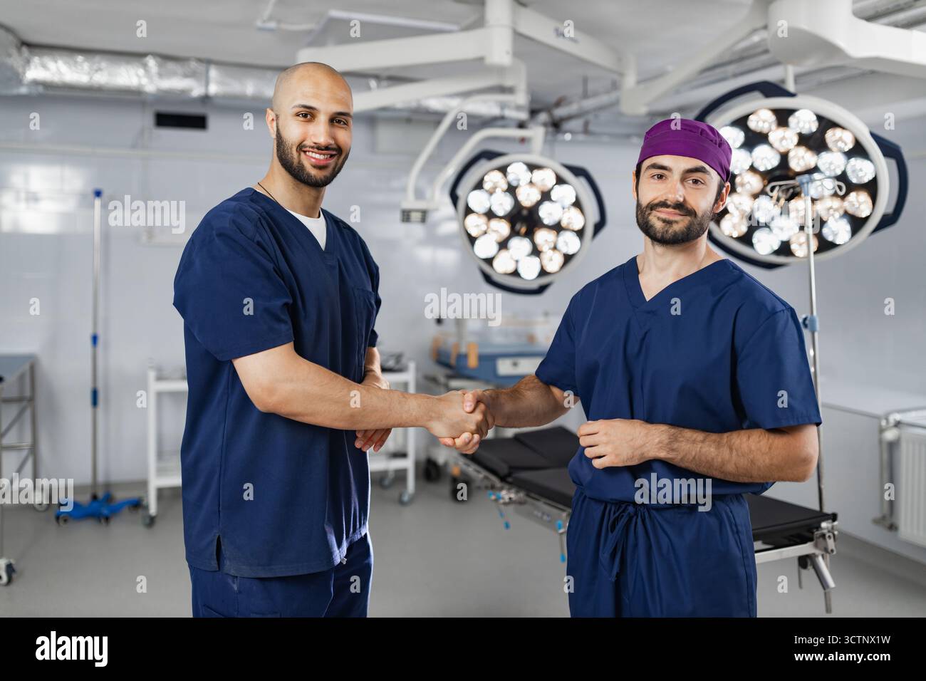 Surgeons Handshake in Operating Room Stock Photo