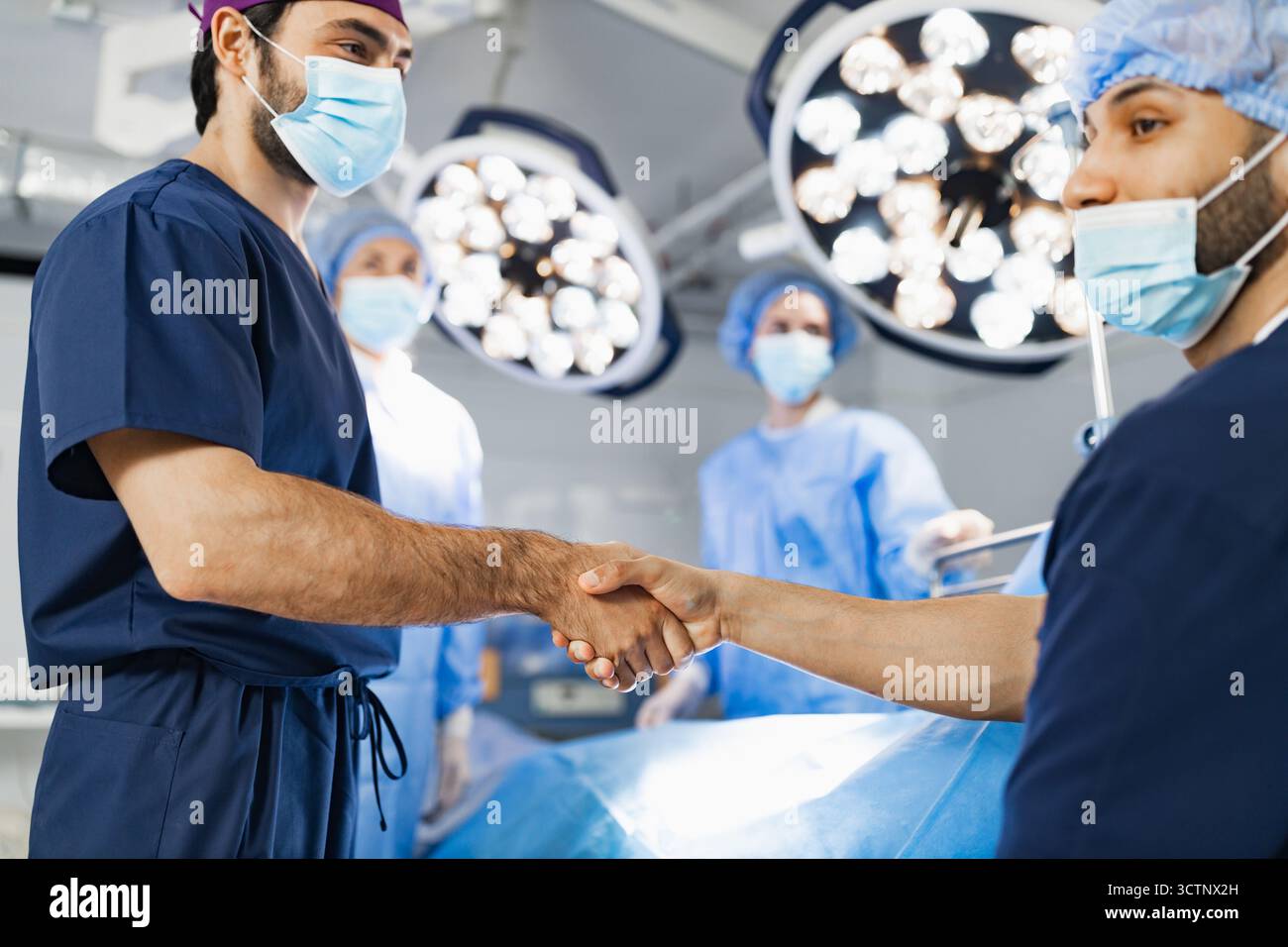 Surgeons Handshake in Operating Room Stock Photo