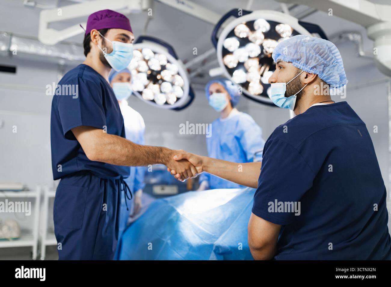 Surgeons Handshake in Operating Room Stock Photo