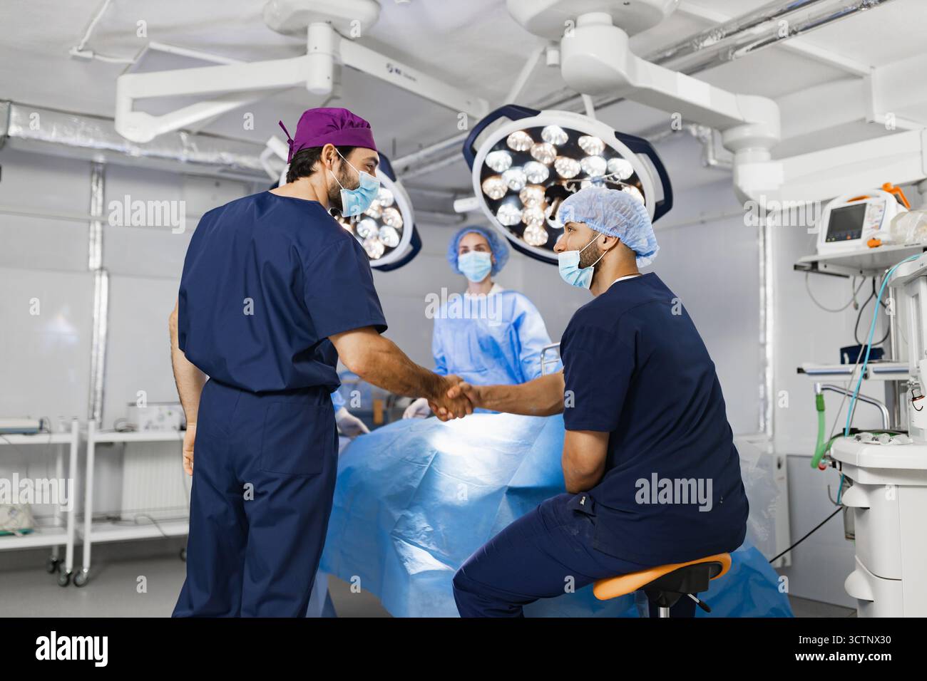 Surgeons Handshake in Operating Room Stock Photo