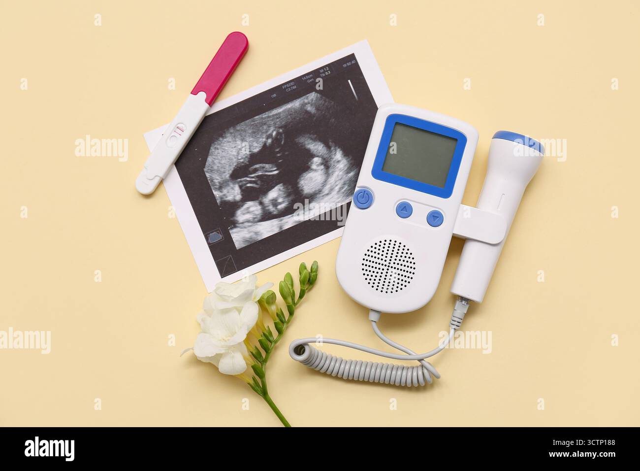 Fetal doppler with sonogram image, pregnancy test and flower on yellow ...
