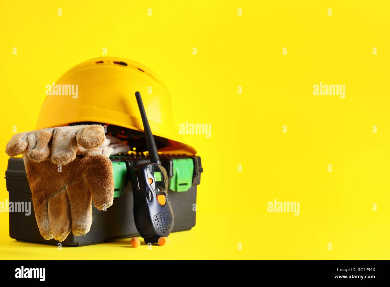 Hardhat, tool box and radio transceiver on yellow background Stock ...