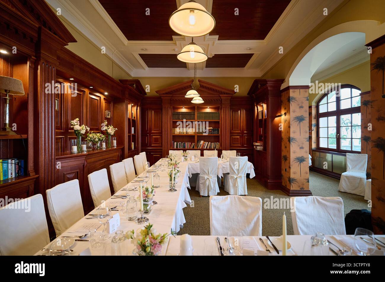 Elegant dining room interior with rich wooden library bookcases and ...