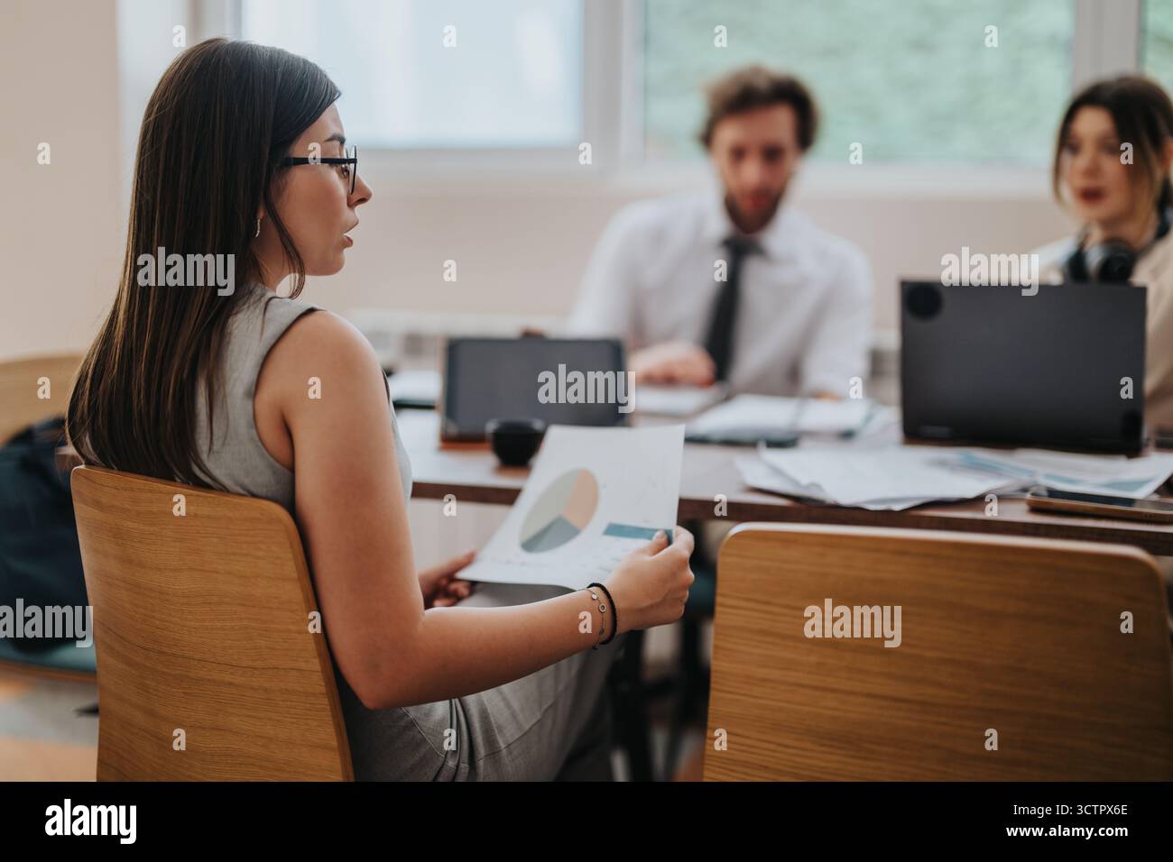Team members discussing project details during an office meeting Stock Photo