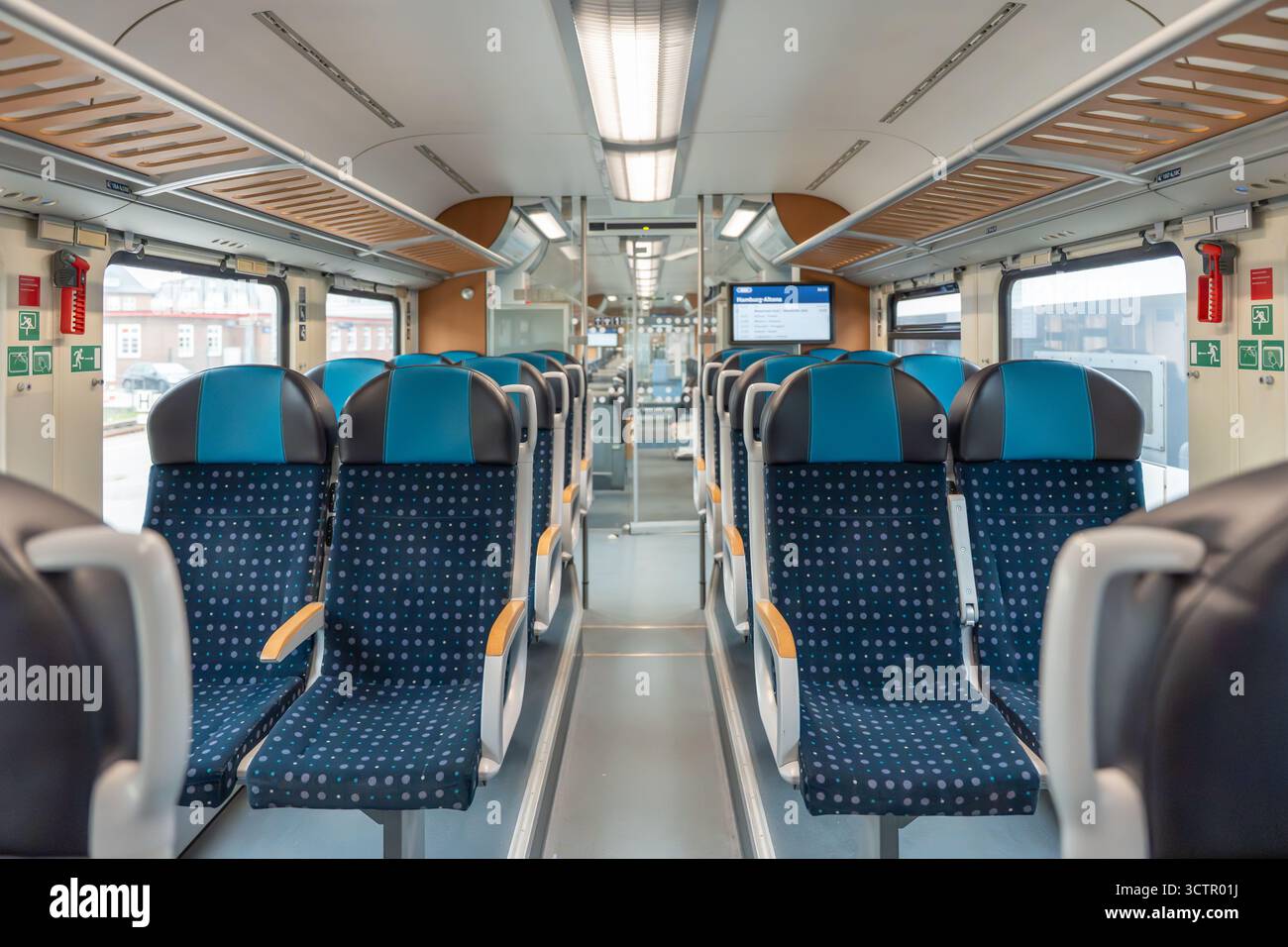 Inside A Train Auto Rack Wide train view. Rows of patterned blue train seats line both sides of ...