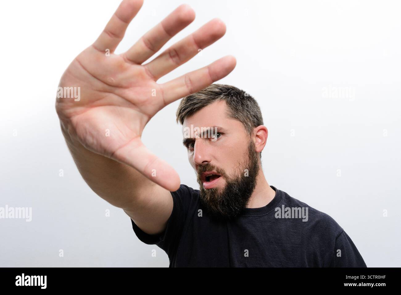 Man with beard raising hand in stop gesture Stock Photo - Alamy