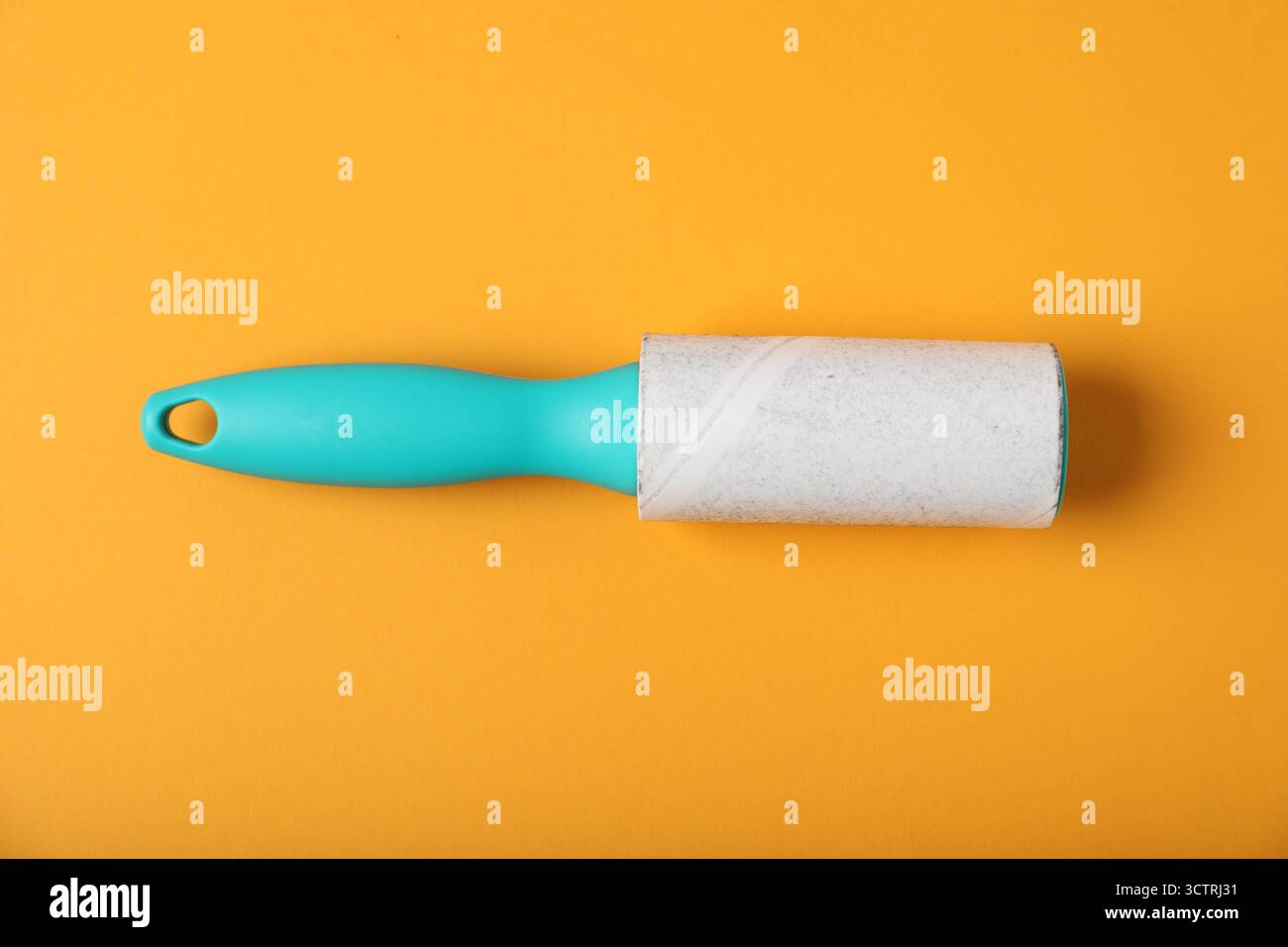 One lint roller on orange background, top view Stock Photo