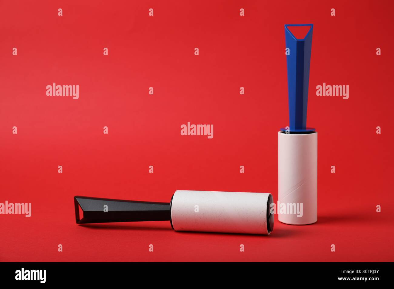 Two sticky lint rollers on red background Stock Photo