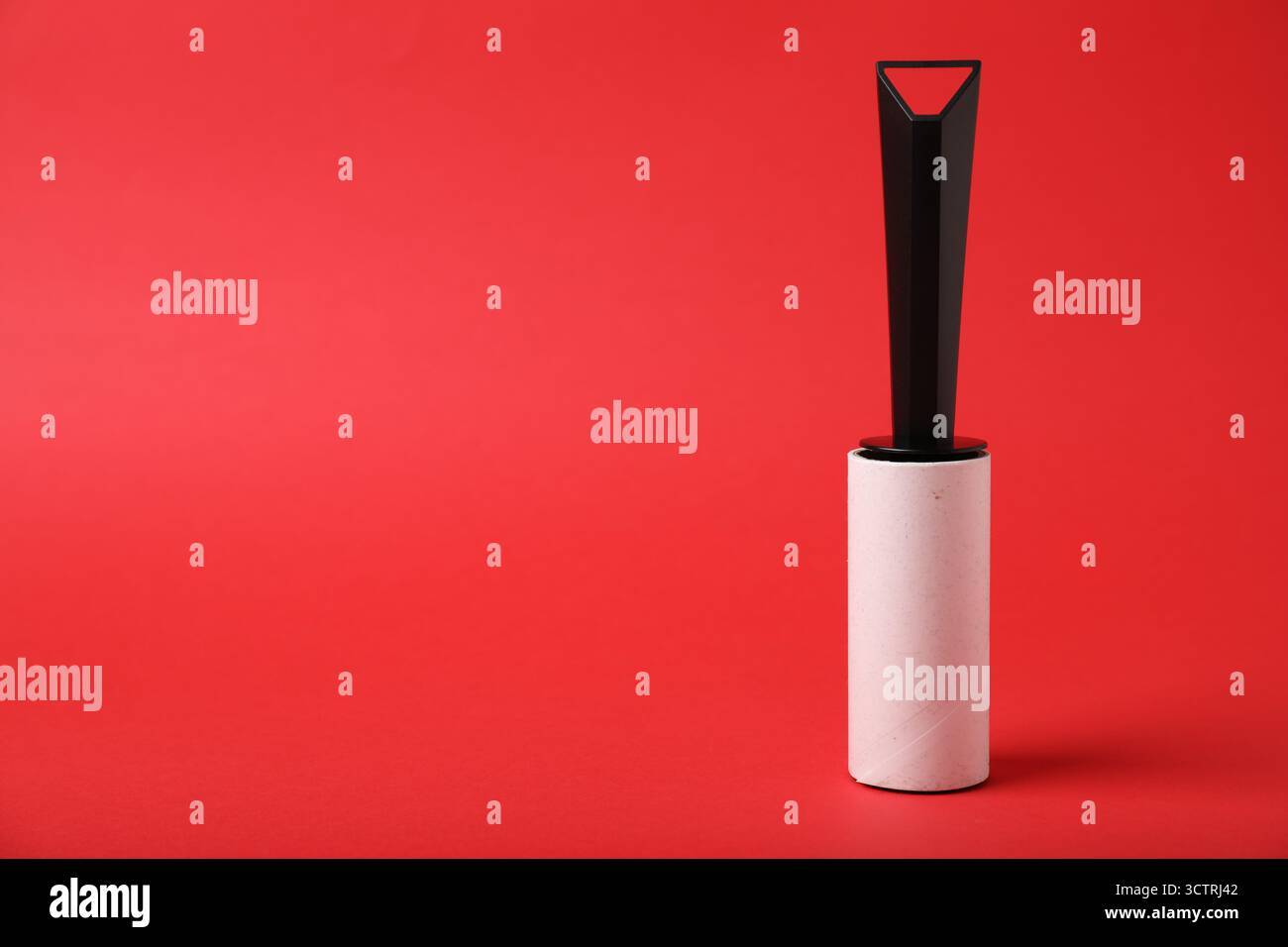One lint roller on red background, space for text Stock Photo