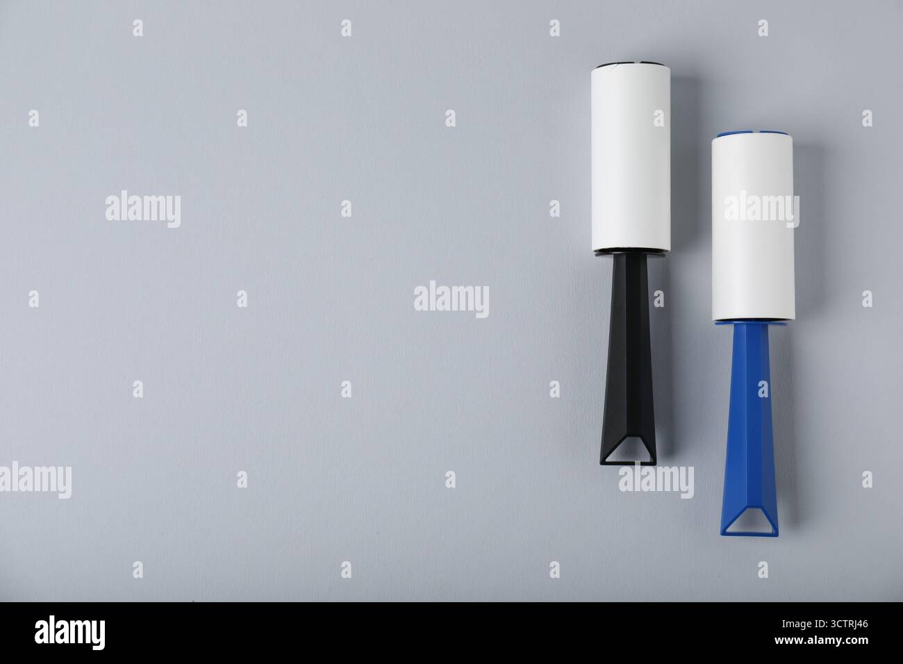 Two lint rollers on light grey background, flat lay. Space for text Stock Photo