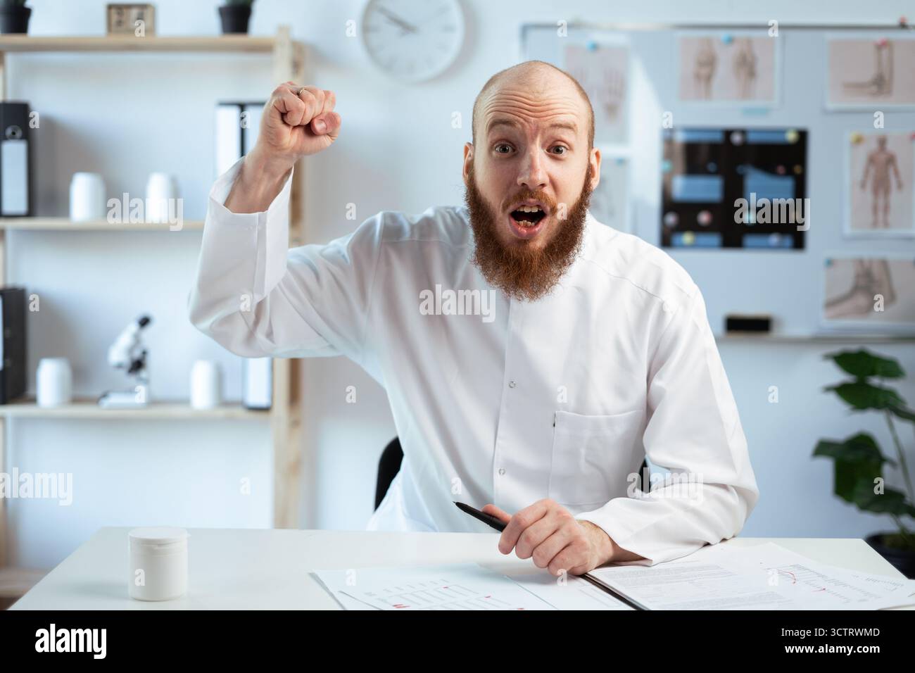 angry aggressive doctor with his fist raised up looking at the camera ...