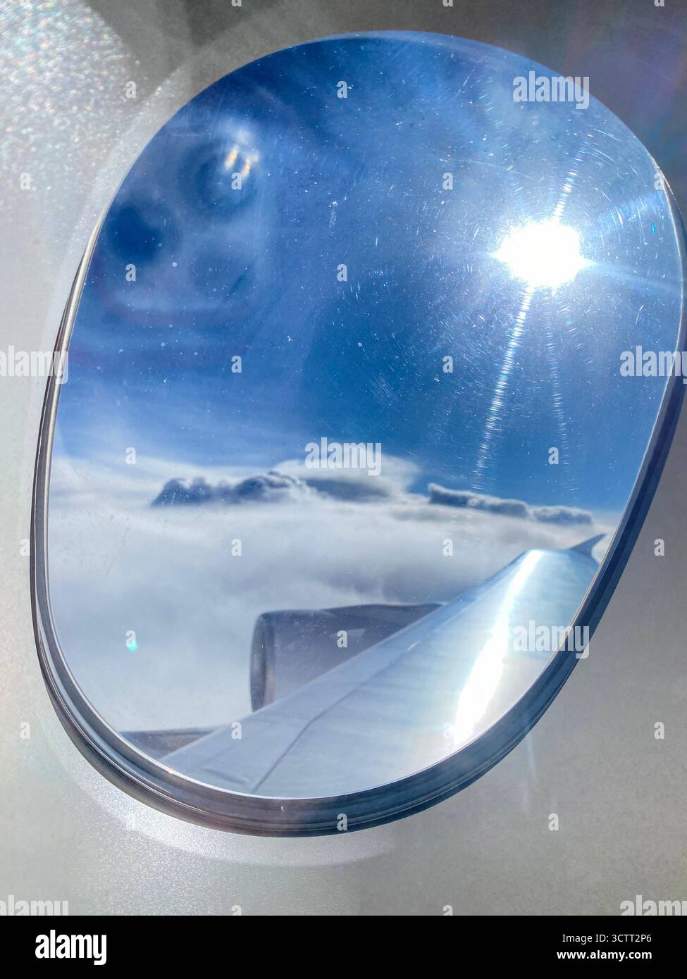 An air passenger's view though the aircraft porthole or window above the blue sky with scattered clouds over the Indian Ocean towards Western Australi - Smartphone Captured Stock Image