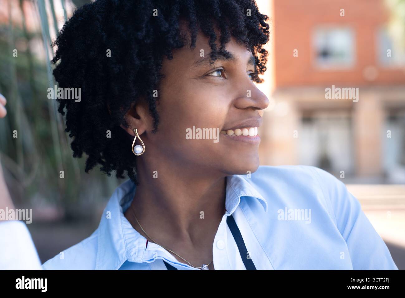 Young black woman with dreadlocks smiling outdoors Stock Photo