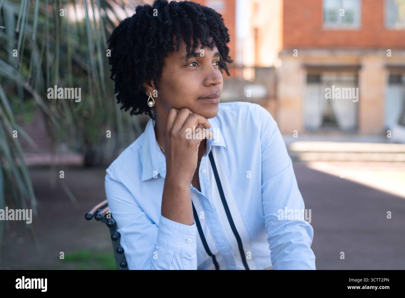 Thoughtful young black woman, outdoors in an urban setting. Stock Photo