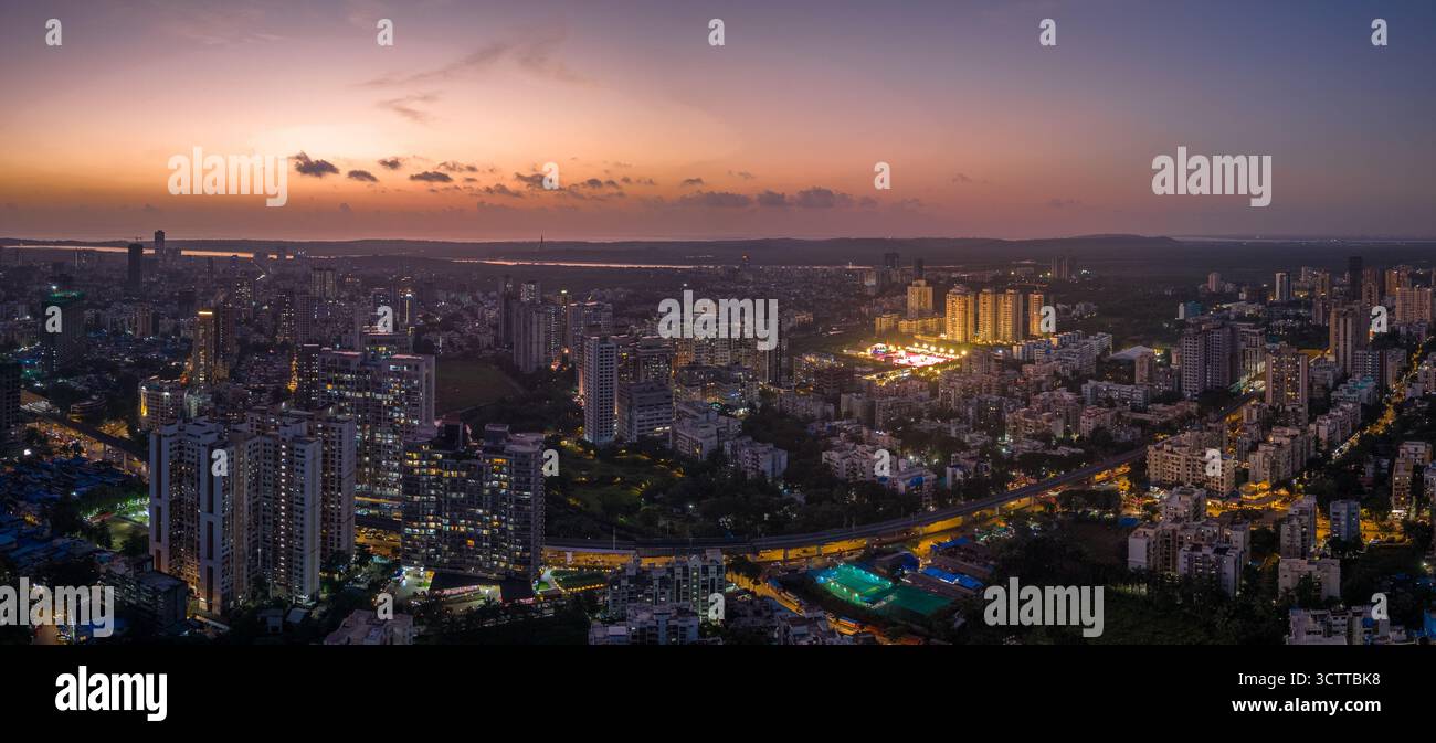 Aerial view of the cityscape with illuminated buildings casting a warm ...