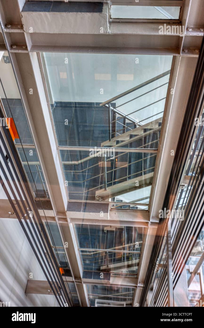 elevator shaft indoors view from inside, view of the staircase from glass doors , steel and cables Stock Photo