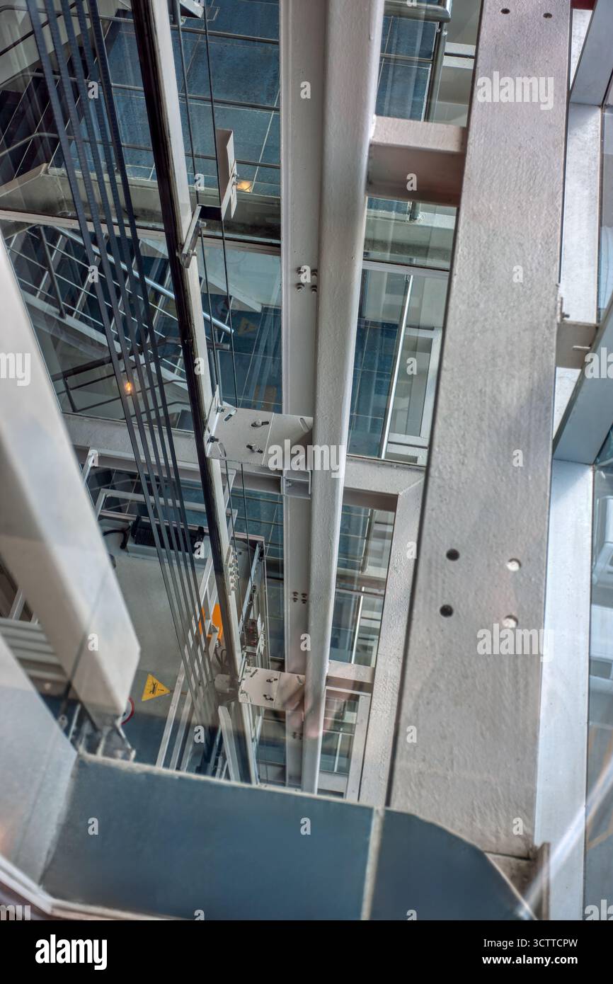 elevator shaft indoors view from inside, view of the staircase from glass doors , steel and cables Stock Photo