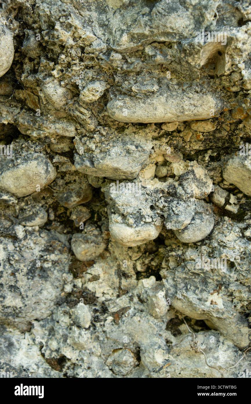 Weathered Stone Wall Texture Showing Cracks and Natural Vertical Patterns. Stock Photo